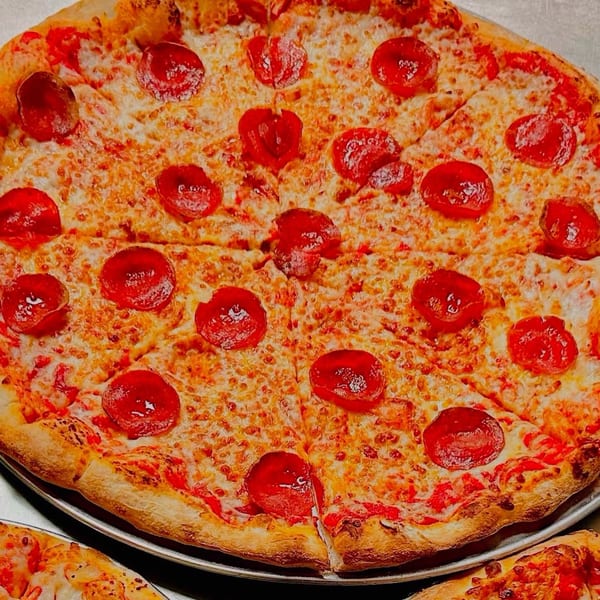 Close-up of a freshly baked, sliced pepperoni pizza from Up North Pizzeria, with melted cheese and crispy crust.