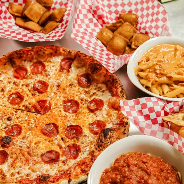 Up North Pizzeria's pepperoni pizza, pasta, and fried ravioli on a table.