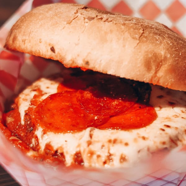 A pizza sub from Up North Pizzeria, with pepperoni, melted cheese, and sauce on a bun.